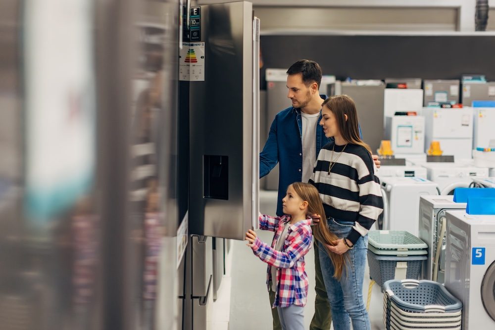 A family looking at refrigerators together while shopping in an appliance store