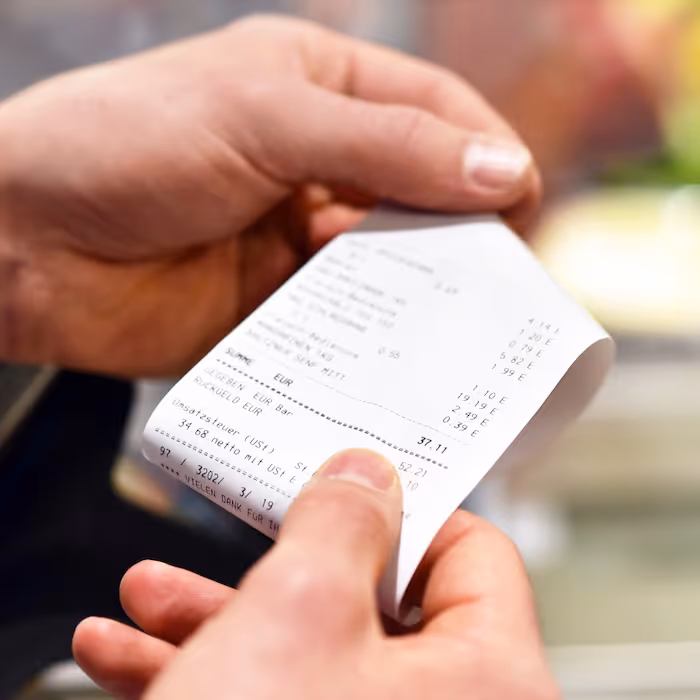 A person holding a paper receipt